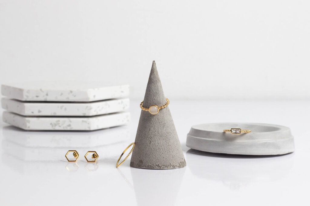 Three gold rings with matching earrings product photography on white background by Atlanta photographer Natalia Tamariz, highlighting elegant jewelry for small brands