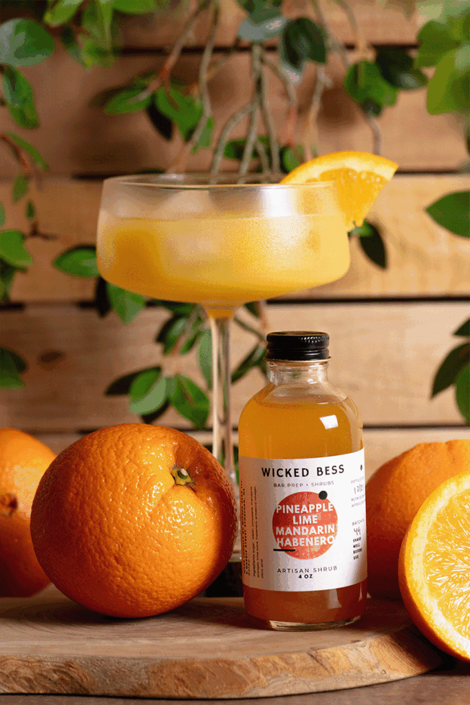 Wicked Bess product photography Wicked Bess juice bottle stop-motion GIF with oranges, a glass of juice, and green background, photographed by Atlanta product photographer Natalia Tamariz, showcasing fresh and vibrant beverage products for small brands